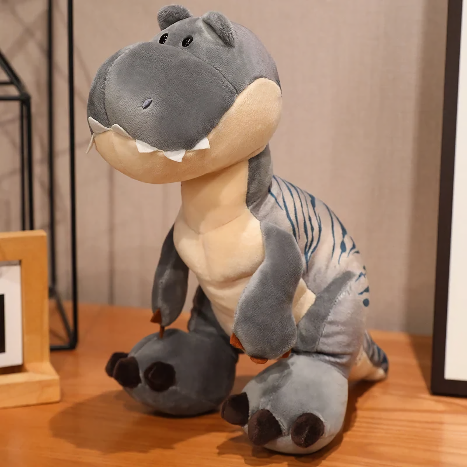 Gray T-Rex plush with cream belly and subtle stripes, standing on a wooden surface.