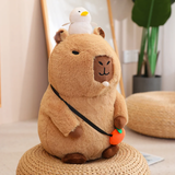 Sitting capybara plush with a white duck and a crossbody strap with an orange charm