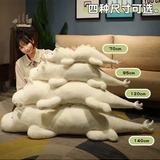 Woman sitting beside a stack of white and mint green dragon plush body pillows labeled with four lengths.