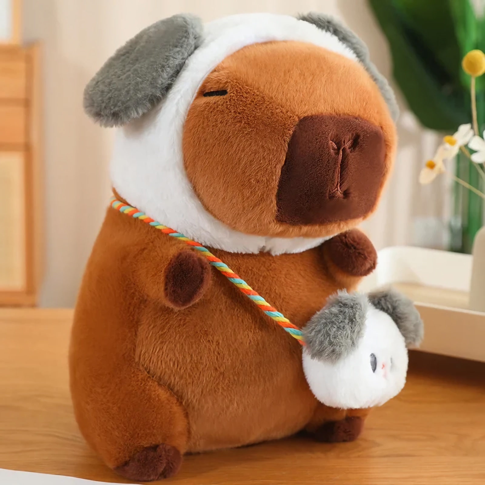 Capybara plush in a dog hood with gray ears and a matching mini bag