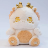 White fluffy baby dragon plush with golden horns and sparkly star eyes, close-up of face on light background.
