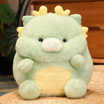 Green pig-dragon plush with cream belly, small horns, on a woven mat in a cozy room.