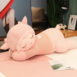 Pink sleeping sheep plush pillow with a knit sweater on a pink blanket