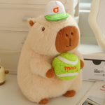 Brown capybara plush with a white cap holding a green tennis ball