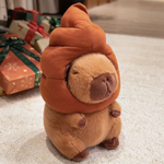 Capybara plush with a brown swirl hat sitting beside gift boxes