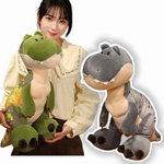 Woman holding green T-Rex dinosaur plush with cream belly and chunky dark feet, gray plush next to her.