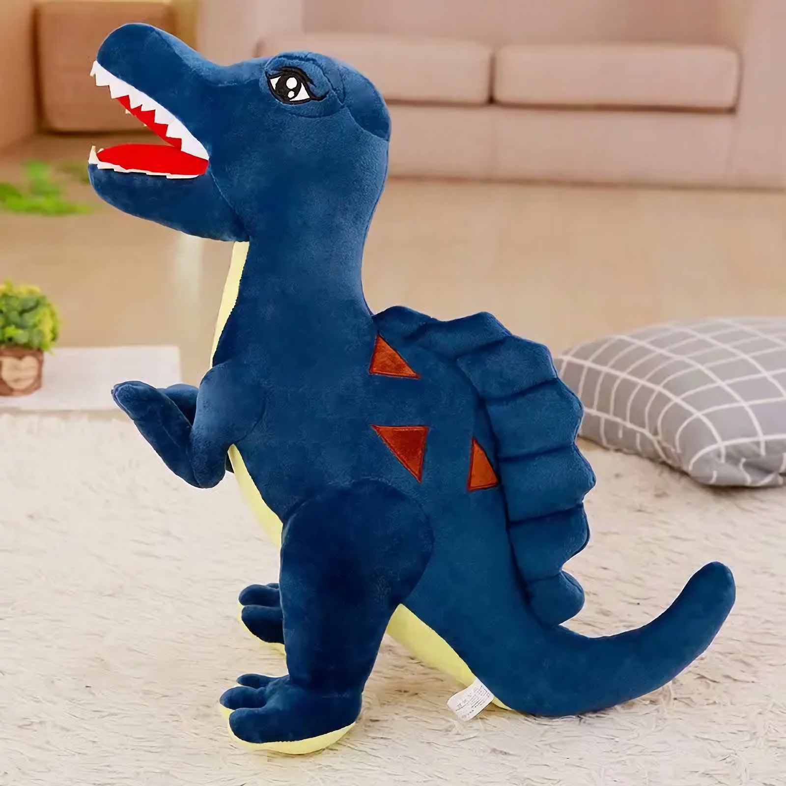 Blue Spinosaurus dinosaur plush with a sail on its back on a rug
