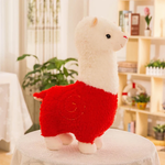Red body alpaca plush with a white head and a stitched swirl on a table