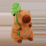 Capybara plush holding a green lotus leaf on a white background