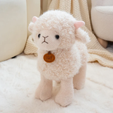 White curly lamb plush with pink ears and an orange chest tag