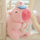 Pink capybara plush with a white cap holding a baseball