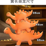 Three stacked orange dinosaur plush toys of varying sizes on a table.