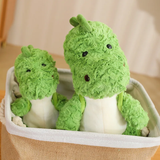 Two green dinosaur plush toys sitting together in a fabric storage basket.