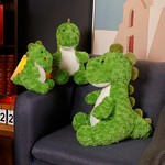Three green dinosaur plush toys sitting on a couch, featuring soft textures and friendly expressions.