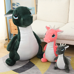 Three plush dinosaur toys in various sizes: a large green one, a medium pink one, and a small gray one, all with cute feature