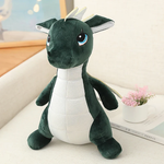 Kawaii dinosaur dragon plush toy with green body, white belly, and small wings, sitting on a light surface.