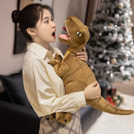 A person in a light shirt holds a plush dinosaur toy, expressing surprise in a cozy indoor setting.