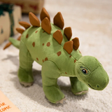 Plush green dinosaur toy with brown spikes, featuring a friendly face and small feet, placed on a light-colored surface.