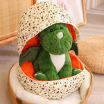 Green plush dinosaur with wings inside a spotted egg-shaped pillow.