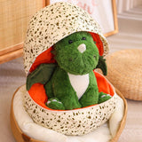 Green plush dinosaur with wings inside a spotted egg-shaped pillow.
