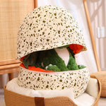 Plush dinosaur toy peeking out from a speckled dragon egg-shaped pillow.
