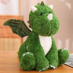 Green plush dinosaur with wings, sitting upright, featuring a soft texture and a friendly expression.