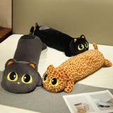 Three long plush pillows shaped like cats, featuring large eyes and different colors, on a bed with a gray mat.