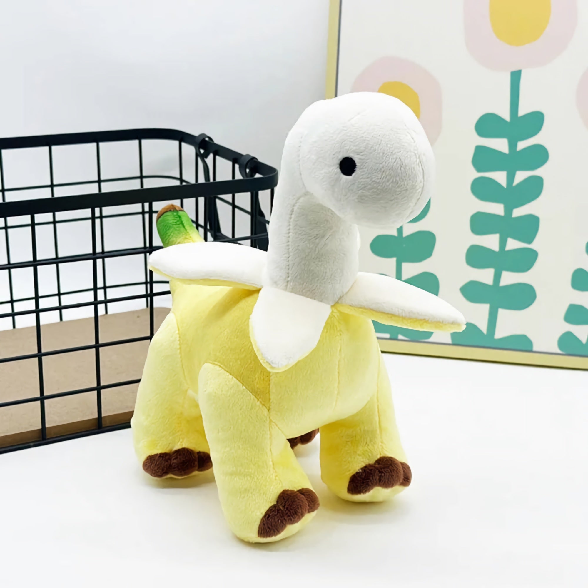 Plush toy resembling a dinosaur with a yellow body and a white neck, featuring a banana-like design.