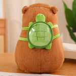 Brown capybara plush with a green turtle-shaped backpack on a wooden surface.