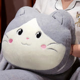 Plush cat-shaped pillow with gray and white fur, held by a person in pajamas.