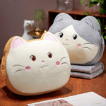 Two plush cat-shaped pillows with smiling faces on a wooden table.