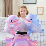Girl holding two plush dinosaur toys with a colorful blanket on her lap.