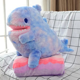 Blue and pink plush dinosaur toy sitting on a matching folded blanket.