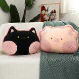 Two plush pillows shaped like a cat and a pig, resting on a textured blanket.