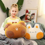 A girl holds a bear-shaped pillow next to a rabbit-shaped pillow, sitting on a blanket in a cozy room.