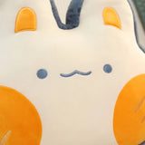 Close-up of a plush pillow featuring a cute animal face with orange ears and cheeks, and a simple smiling expression.