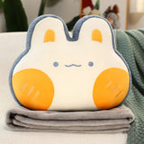 Plush pillow shaped like a bunny with orange cheeks, resting on a folded gray blanket.