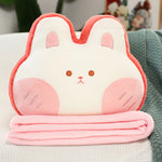 Plush pillow shaped like a bunny with a pink blanket folded underneath it.