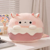 A plush pillow shaped like a cute dessert with a smiling face, pink and white colors, and small ears.