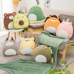 A collection of colorful plush animal pillows and a green travel blanket arranged on a chair and floor.