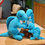 Three blue plush dinosaur toys in various sizes, sitting around a small basket on a wooden table.
