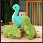 Three plush dinosaur toys: a blue long-necked dinosaur, a green Triceratops, and a green Tyrannosaurus Rex.