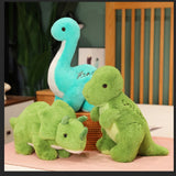 Three plush dinosaur toys: a blue long-necked dinosaur, a green Triceratops, and a green Tyrannosaurus Rex.