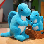 Two blue plush dinosaur toys, one large and one small, are sitting beside a woven basket on a wooden surface.