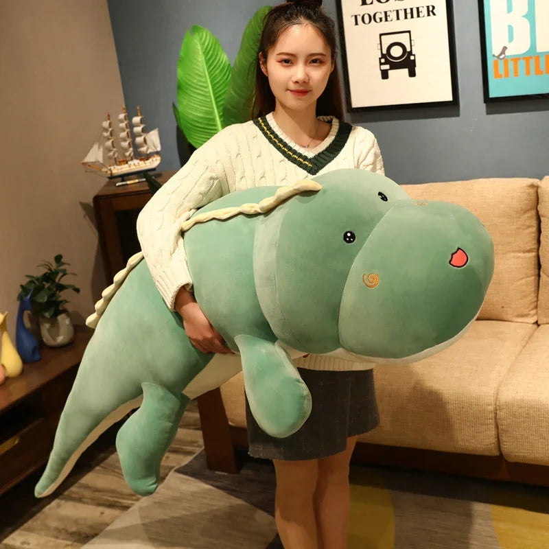 A person holds a large, green dinosaur plush pillow in a cozy living room setting.