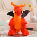 A plush dragon with orange and black features, sitting upright with small wings and a friendly expression.