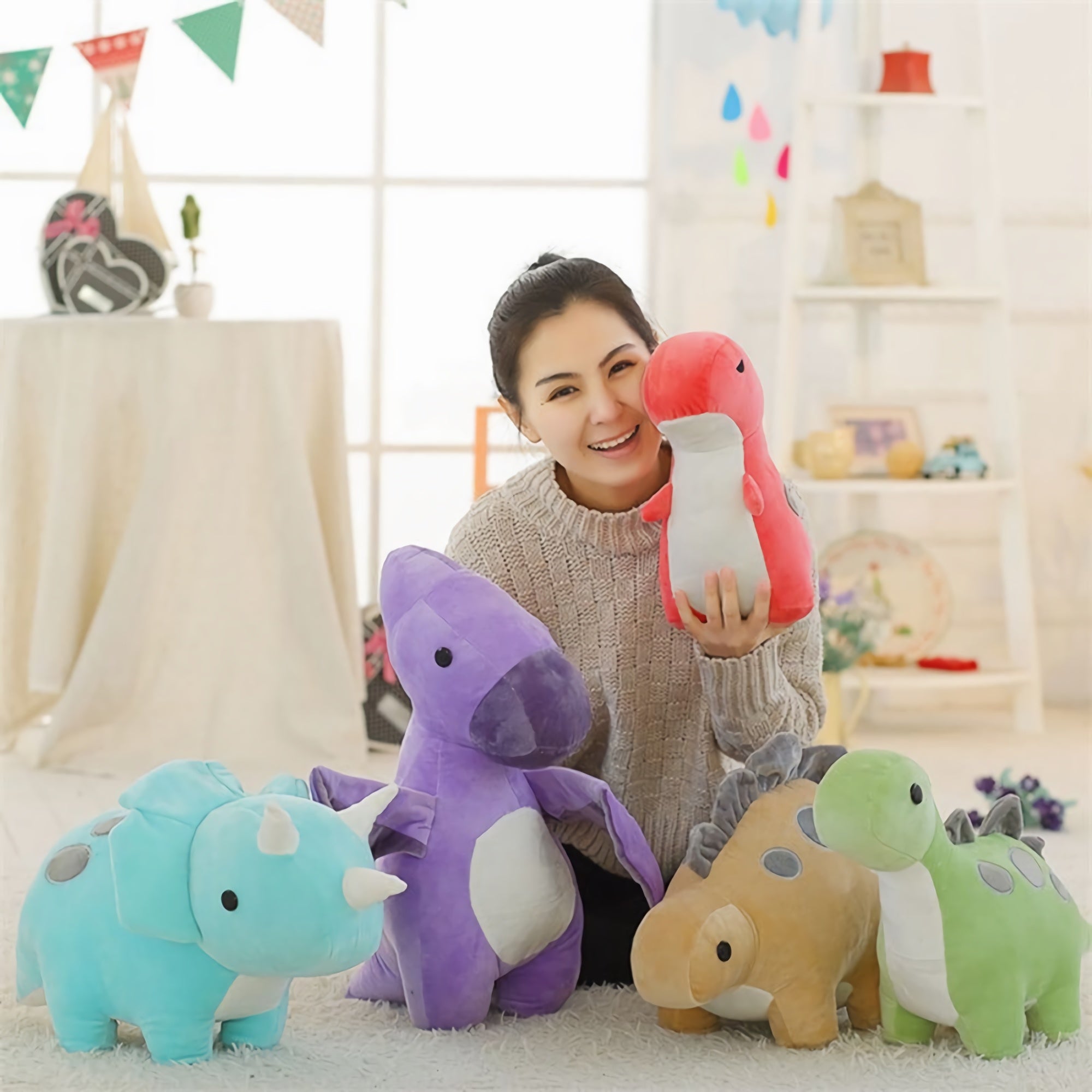 A person holding a red and white dinosaur plush toy surrounded by four other pastel dinosaur plush toys.