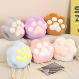 Colorful plush paw-shaped cushions in various pastel shades arranged on a light-colored surface.