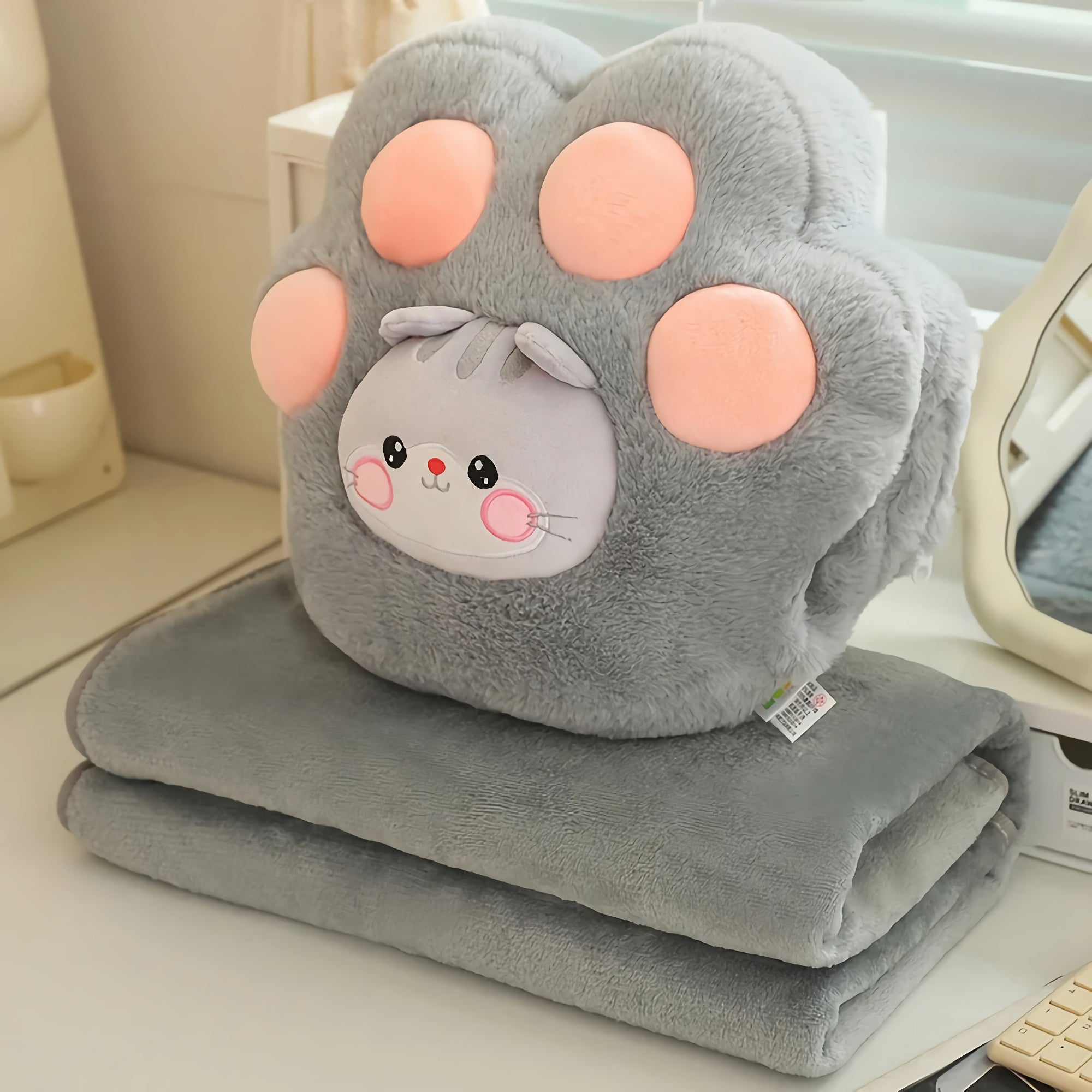 Gray plush blanket set featuring a paw-shaped pillow with a cute animal face and pink paw pads.