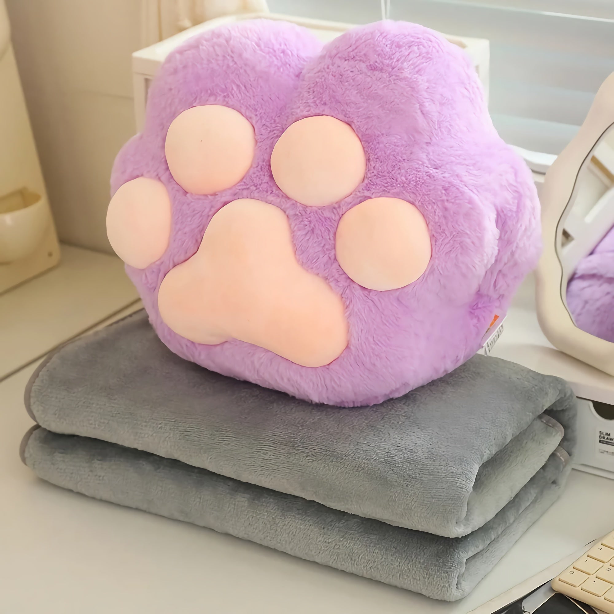 Purple paw-shaped plush on a folded gray blanket.